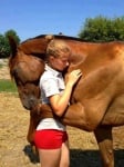 Момиче прегръща кон
